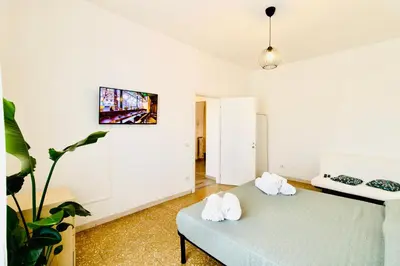 a room with a couch and a tv on the wall at PLANT HOUSE Roma San Paolo in Rome