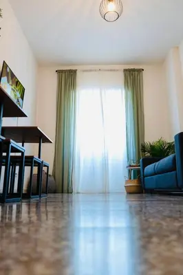 a living room with a blue couch and a window at PLANT HOUSE Roma San Paolo in Rome