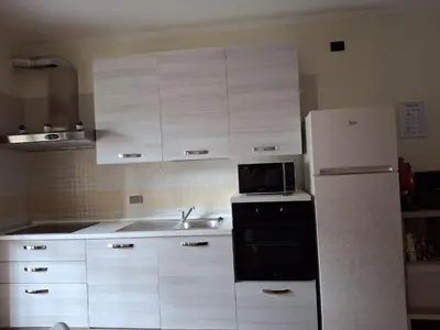 a kitchen with white cabinets and a white refrigerator at Mary's house in Rome