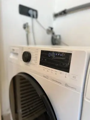 a white washing machine sitting in a room at Mary's house in Rome