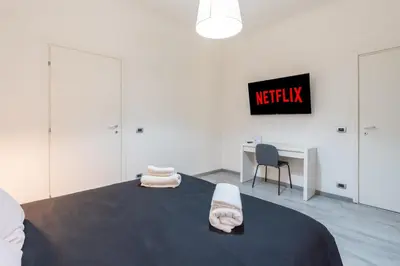 a bedroom with a bed with a desk and a monitor at Amazing apartment near to Colosseo and subway in Rome