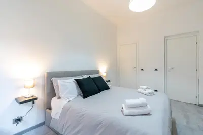 a bedroom with a large white bed with towels on it at Amazing apartment near to Colosseo and subway in Rome