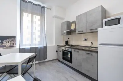a kitchen with a table and a white refrigerator at Amazing apartment near to Colosseo and subway in Rome