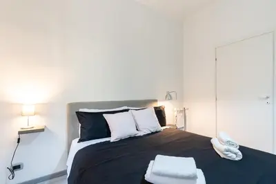 a bedroom with a bed with black and white pillows at Amazing apartment near to Colosseo and subway in Rome