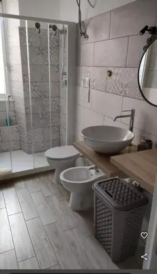 a bathroom with two toilets and a sink and a shower at Appartamento Elena & Chiara in Rome