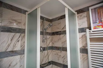 a shower in a bathroom with a stone wall at Anna’s Crazy Place in Rome