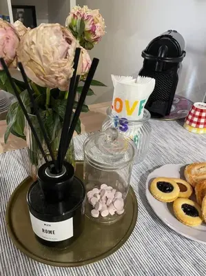 a table with a vase with flowers and a plate of pastries at Anna’s Crazy Place in Rome