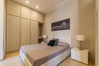 a bedroom with a large bed and a cabinet at GuestHost - Bright Apartment near Villa Borghese in Rome