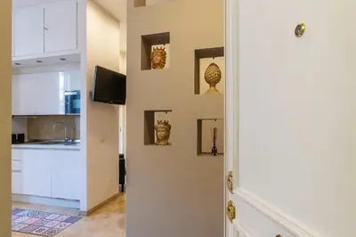 a hallway with a kitchen with a tv and sculptures on the wall at GuestHost - Bright Apartment near Villa Borghese in Rome
