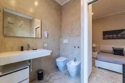 a bathroom with a sink and a toilet and a bed at GuestHost - Bright Apartment near Villa Borghese in Rome