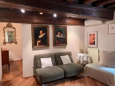 a living room with a couch and portraits on the wall at Torre della Scimmia apartment in Rome