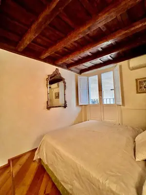 a bedroom with a large bed and a mirror at Torre della Scimmia apartment in Rome