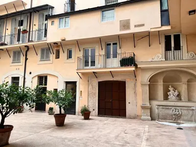 a large building with a gate and a building with trees at Torre della Scimmia apartment in Rome