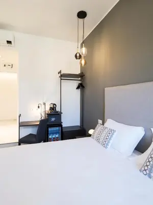 a bedroom with a white bed and a mirror at Savoia Rooms Roma in Rome