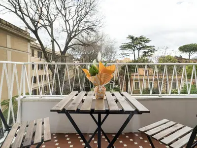 a table on a balcony with a vase on it at Savoia Rooms Roma in Rome