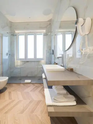 a white bathroom with a sink and a mirror at Savoia Rooms Roma in Rome