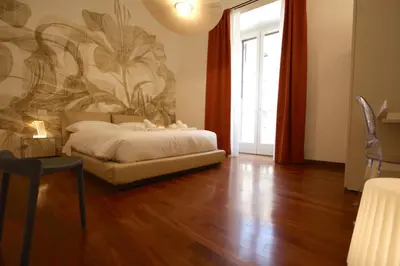 a bedroom with a bed and a painting on the wall at Aletheia Èlite - Elegant 2 BR in Rome
