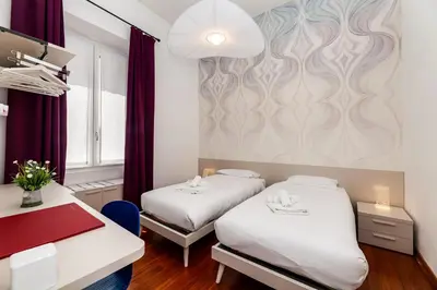 a hotel room with two beds and a wall at Aletheia Èlite - Elegant 2 BR in Rome
