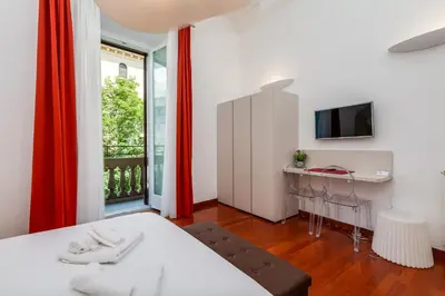 a bedroom with a bed and a desk and a window at Aletheia Èlite - Elegant 2 BR in Rome