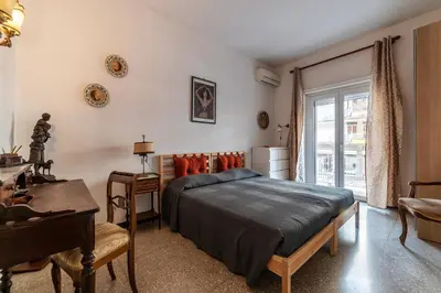 a bedroom with a bed and a desk and a window at GuestHost - San Giovanni in Laterano Comfy Apartment in Rome