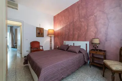 a bedroom with a bed and a pink wall at GuestHost - San Giovanni in Laterano Comfy Apartment in Rome