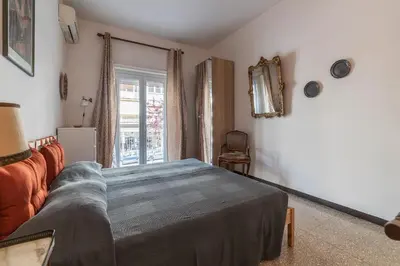 a bedroom with a bed and a couch and a window at GuestHost - San Giovanni in Laterano Comfy Apartment in Rome