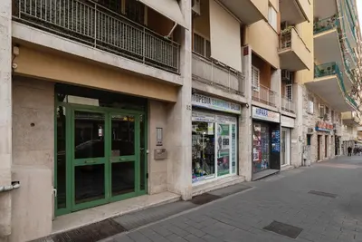 an empty street in a city with a green door at GuestHost - San Giovanni in Laterano Comfy Apartment in Rome
