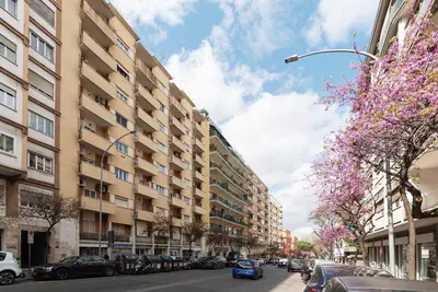 a city street with parked cars and buildings at GuestHost - San Giovanni in Laterano Comfy Apartment in Rome