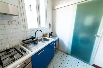 a small kitchen with blue cabinets and a sink at La Pietra al Pigneto in Rome