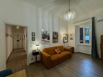 a living room with a couch and a chandelier at Casa Marin - Metro Malatesta in Rome