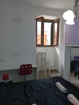 a bedroom with a bed and a desk and a window at Pigneto House in Rome