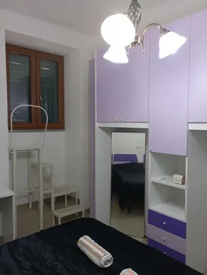 a bedroom with a bed and a purple cabinet and lights at Pigneto House in Rome