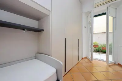 a bedroom with a white bed and a large window at suity I cozy anglona apartment in Rome