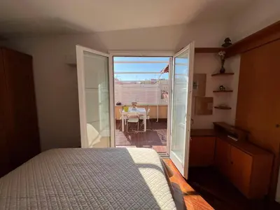 a bedroom with a bed and a balcony with a table at BUBUS Terrace in Rome