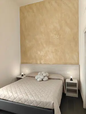 a bedroom with a bed with a large painting on the wall at Velvet Rooms in Rome