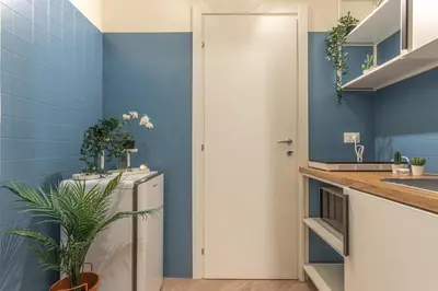 a kitchen with blue walls and a refrigerator at Vittoria Garden Suites in Rome