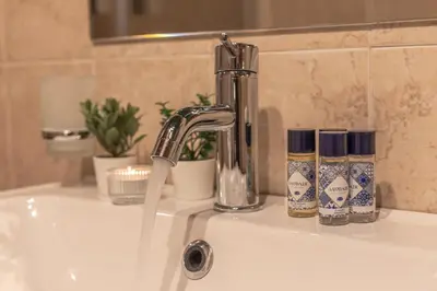 a sink with a faucet and two candles on it at Vittoria Garden Suites in Rome
