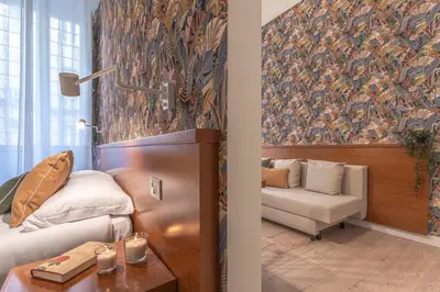 a room with a bed and a couch and a chair at Vittoria Garden Suites in Rome