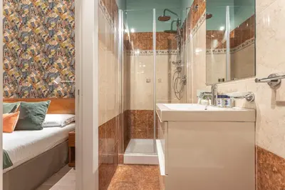 a bathroom with a shower and a sink and a tub at Vittoria Garden Suites in Rome