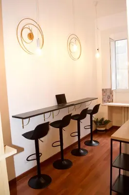 a room with a table and stools with a laptop on it at AmareRomaRooms in Rome
