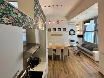 a kitchen and living room with a table and a couch at Relais Romagnosi in Rome