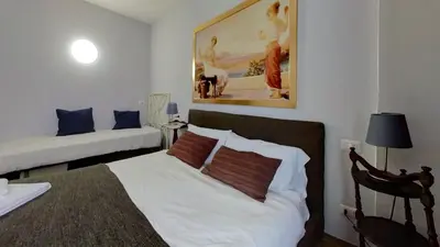 a bedroom with a bed and a couch in it at Relais Romagnosi in Rome