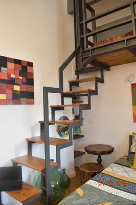 a spiral staircase in a living room with a table at Trastevere St Ariabianca House in Rome