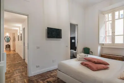 a white bedroom with a bed and a hallway at New Prati Luxury Apartment in Rome