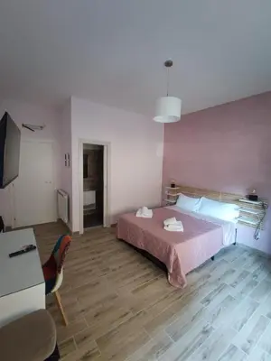 a bedroom with a bed and a desk and a television at Style House 74 in Rome