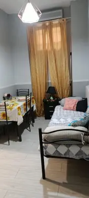 a bedroom with two beds and a dining room with two tables at Sunflower House in Rome