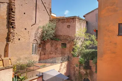 an old brick building with a balcony in an alley at Ciambella Arch Apartment for 6 people @Largo Argentina in Rome