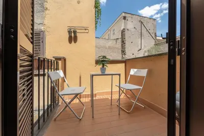 two chairs and a table on a balcony at Ciambella Arch Apartment for 6 people @Largo Argentina in Rome