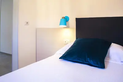 a bedroom with a bed with a blue pillow on it at Lele Rooms Termini in Rome
