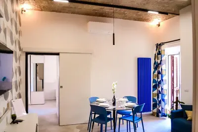 a dining room with a table and blue chairs at Lele Rooms Termini in Rome